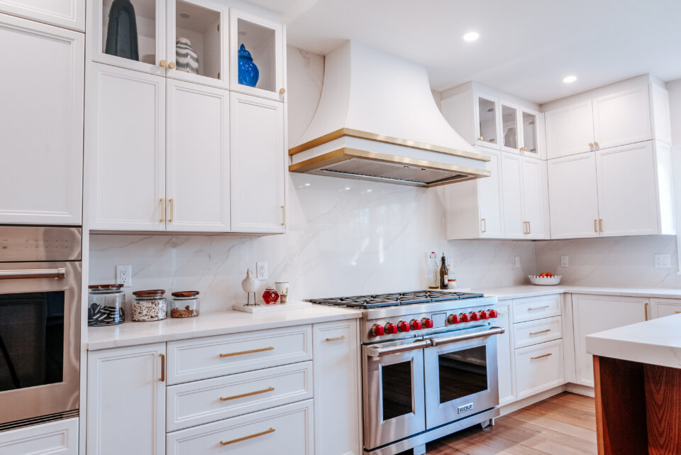 Wyckoff NJ kitchen featuring a statement stovetop, white cabinetry with gold accents, and a clean, functional cooking space with upscale design.